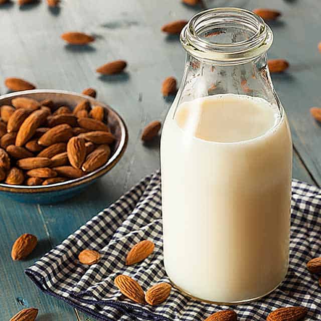 Glass of milk and bowl of almonds