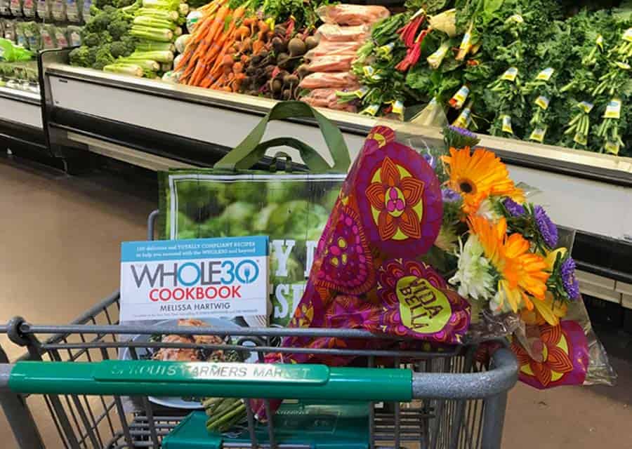 Whole30 meal plan cookbook, fresh flowers and produce in a grocery store.