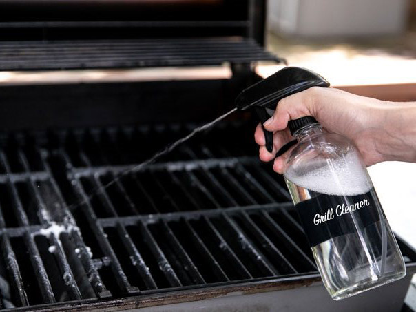 Bottle of Grill Cleaner Spray being sprayed on grill