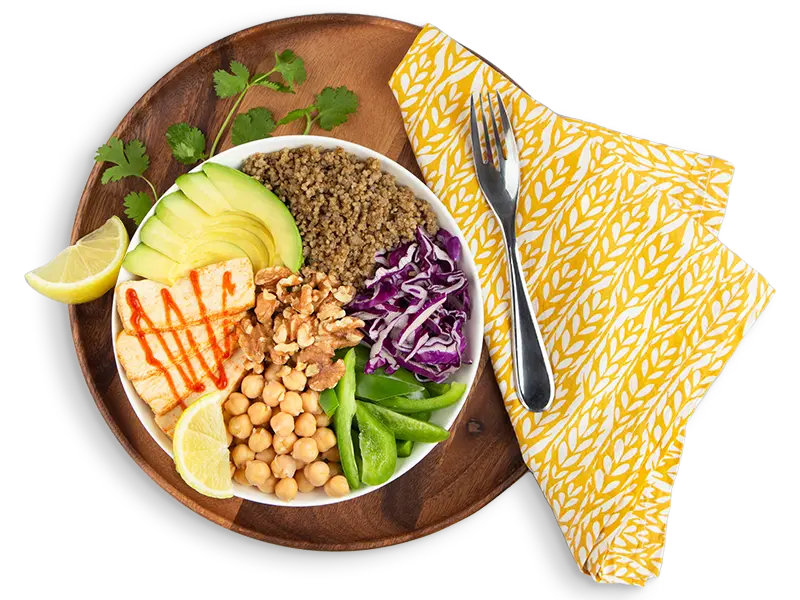 Bowl of plant-based foods on a brown cutting board.