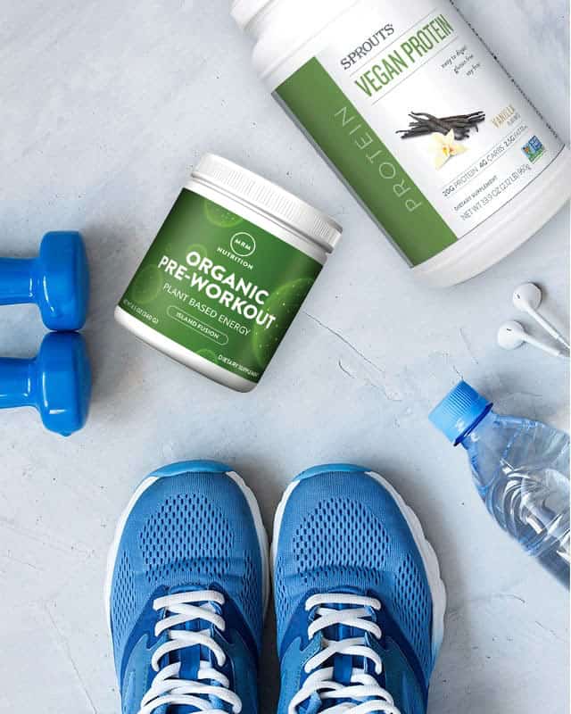 sports nutrition supplements surrounded by workout equipment
