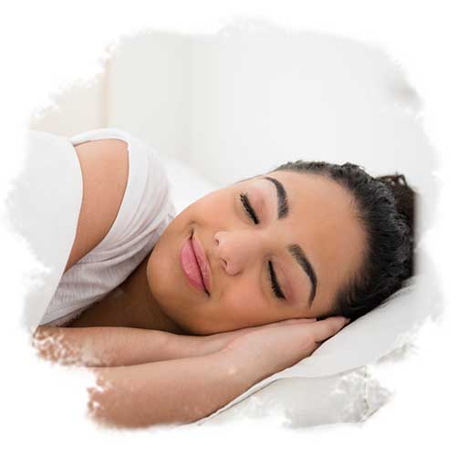 A close-up of someone sleeping on a pillow in bed.
