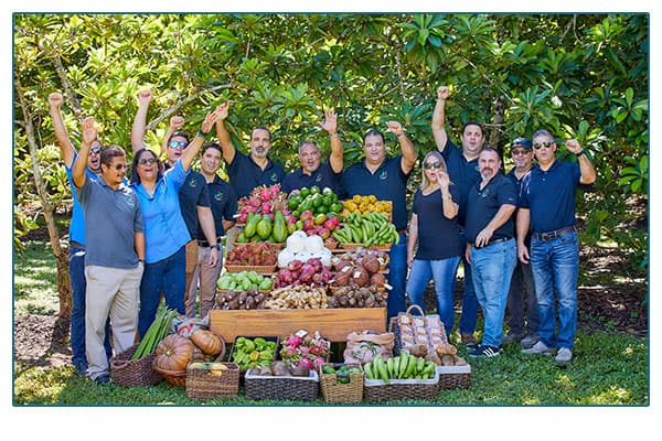 JC tropics family standing around a fruit stand.