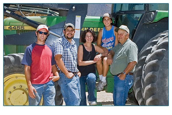 Disanti family portrait in front of a tractor.