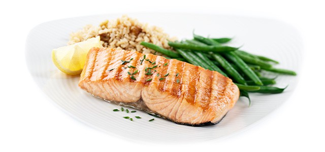 cooked salmon on a plate with rice and green beans