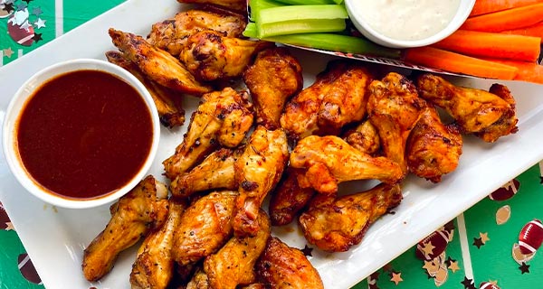 Chicken wings on a serving platter with sauce