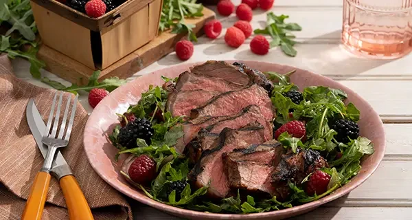 balsamic glazed NY steak with an arugula salad in a bowl