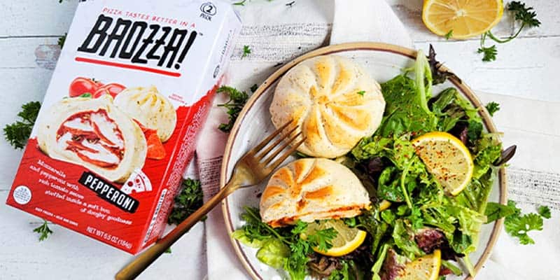 Baozza pizza snacks next to a plate of salad