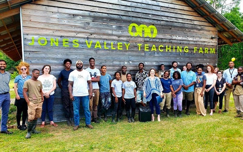 group of people in front of a jones valley teaching farm barn