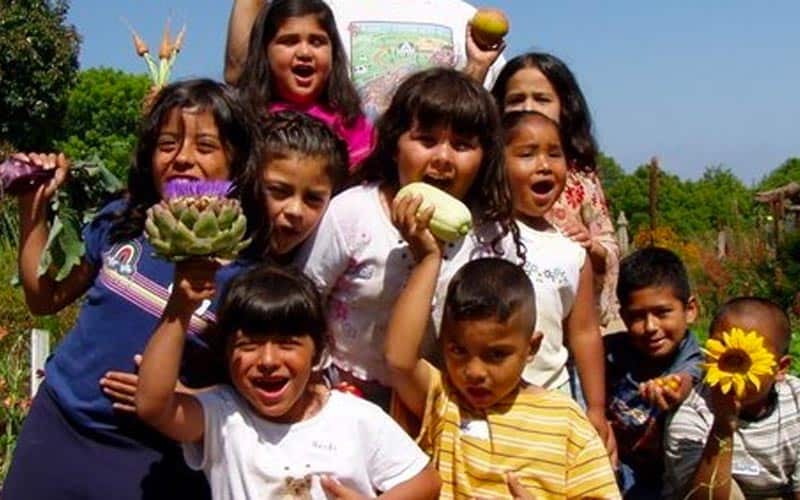 kids holding up produce