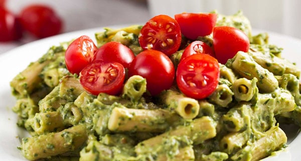 Avocado penne with tomatoes in a serving dish.