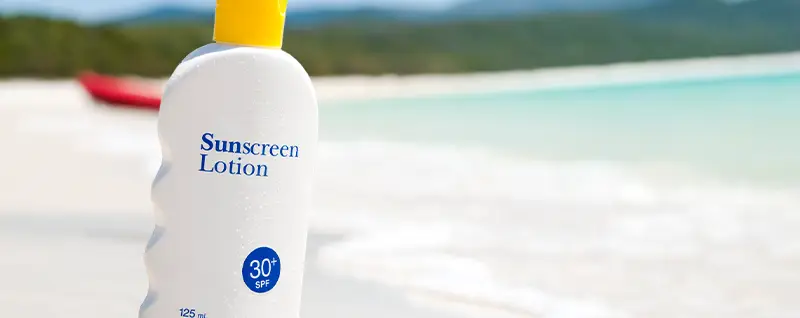 Sunscreen bottle with lake in background