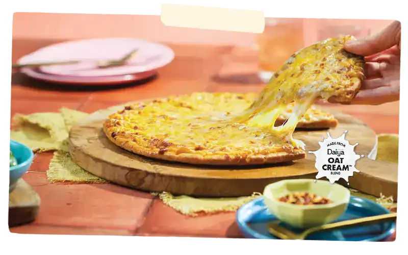 Daiya oat cream cheese callout in front of pizza