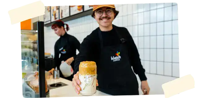 man handing a coffee to a customer